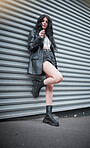 Young woman, fashion and streetwear with gen z punk style, outdoor and trendy, edgy and stylish in urban city. Youth, focus and beauty with rock aesthetic, fashion model in designer clothes in London