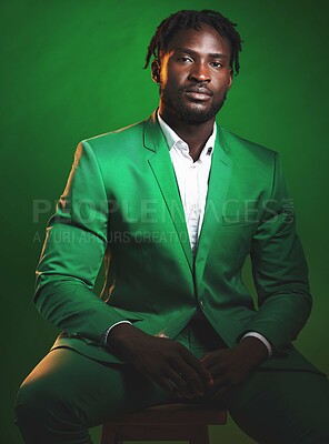 Buy stock photo Fashion, formal and black man in a green suit sitting on a chair in studio with a luxury outfit. Elegant, stylish and portrait of an African male model with fashionable clothes isolated by background