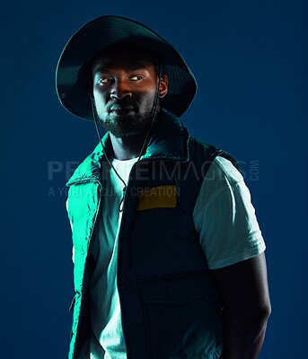 Buy stock photo Fashion, shadow and black man model in a studio with a cool, stylish and casual outfit with lighting. Edgy, style and trendy fashionable African male posing while isolated by a blue background.