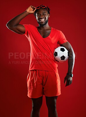 Buy stock photo Black man, soccer ball and football in studio with happiness and red clothes with sunglasses and a positive mindset for sports. Portrait of a male from France happy and laughing in summer fashion