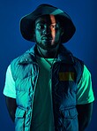Trendy, casual and portrait of a black man in a studio with a cool, stylish and edgy outfit. Fashion, style and African male model with modern clothes posing while isolated by a blue background.