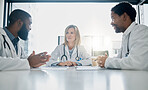 Healthcare, meeting and team of doctors talking in hospital, clinic or health care facility boardroom. Teamwork, communication and medical workers in discussion, conversation and speaking with paper