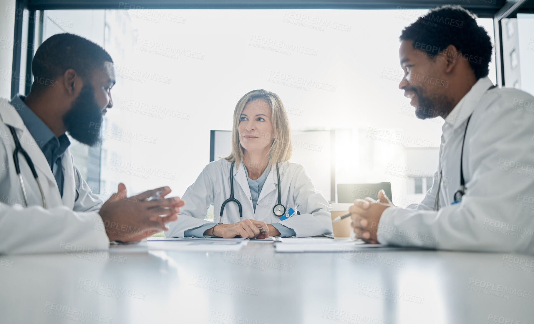 Buy stock photo Healthcare, meeting and team of doctors talking in hospital, clinic or health care facility boardroom. Teamwork, communication and medical workers in discussion, conversation and speaking with paper