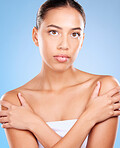 Skincare, beauty and portrait of a woman in a studio for natural, self care and body care treatment. Health, wellness and girl model from Brazil with a facial routine isolated by a blue background.
