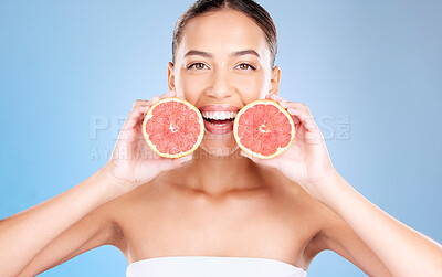 Buy stock photo Woman, studio portrait and grapefruit for skincare, natural cosmetic or health by blue background. Model, fruit and smile for nutrition, vitamin c or self care beauty for aesthetic by studio backdrop