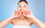 Woman, studio portrait and grapefruit for skincare, natural cosmetic or health by blue background. Model, fruit and smile for nutrition, vitamin c or self care beauty for aesthetic by studio backdrop
