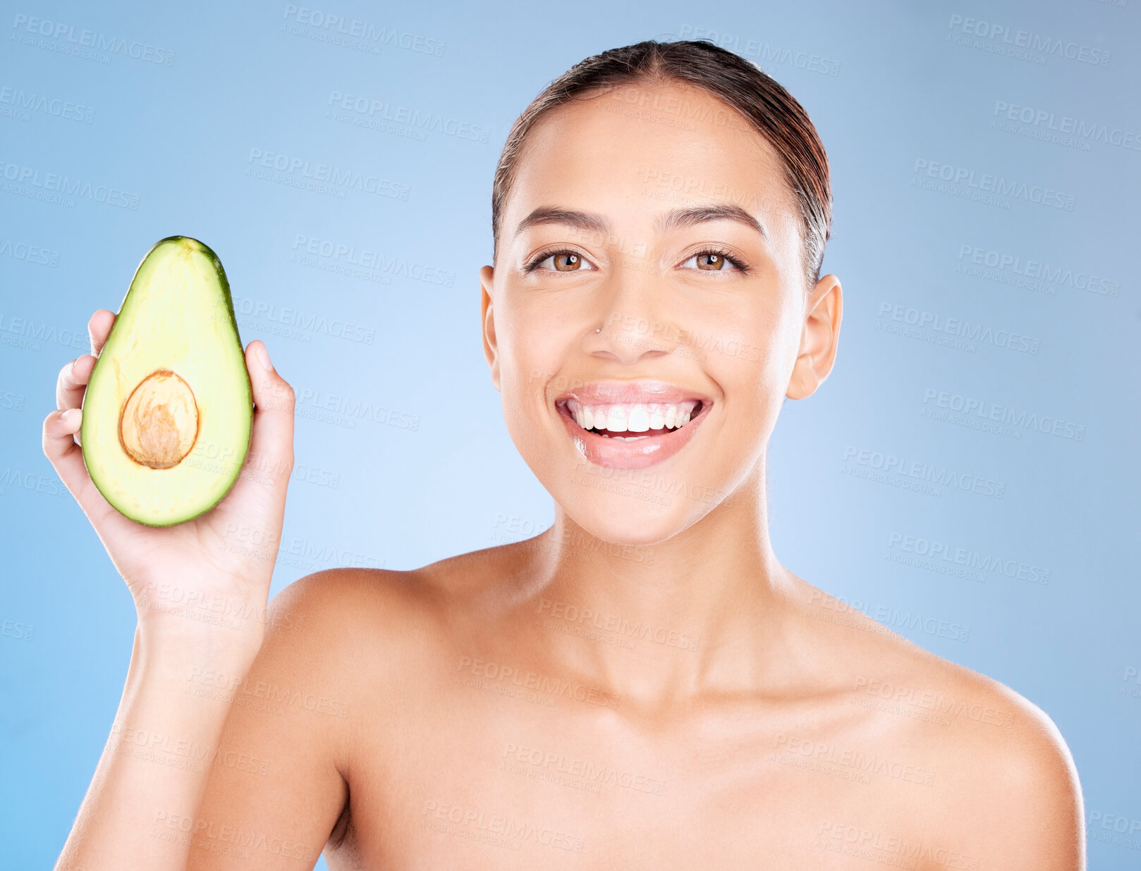 Buy stock photo Woman, studio portrait and avocado skincare with smile, health or wellness by blue background. Model, fruit and face with natural cosmetic beauty, glow or healthy aesthetic with self care by backdrop
