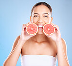 Skincare, beauty and portrait of a woman with grapefruit for a natural, organic and healthy face routine. Cosmetic, wellness and girl model from Mexico with a tropical citrus fruit by blue background