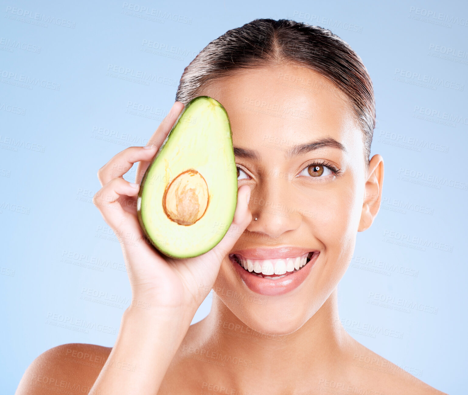 Buy stock photo Woman, studio portrait and avocado skincare with smile, health or wellness by blue background. Model, fruit and face with natural cosmetic beauty, glow or healthy aesthetic with self care by backdrop