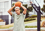 Basketball, young man and basketball player with sport in park with portrait in city and exercise outdoor. Fitness, athlete on basketball court, focus and urban with sports motivation and training.