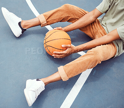 Buy stock photo Basketball, hands and fitness with a sports man sitting alone on a court, holding a ball from above. Basketball court, break and exercise with a male basketball player or athlete resting at practice