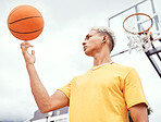 Sports, fitness and man spinning basketball on court outdoors before workout, exercise or practice. Basketball court, balance and young male player with ball on finger getting ready for training.
