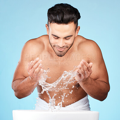 Buy stock photo Face, water splash and skincare of man cleaning in studio isolated on a blue background. Hygiene, water drops and male model washing, bathing or grooming for healthy skin, facial wellness or beauty.