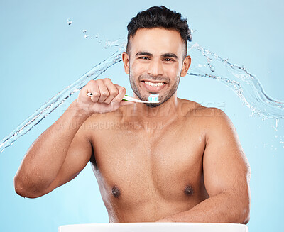 Buy stock photo Teeth, dental care and water splash, man with toothbrush and toothpaste on blue background with smile on face. Morning routine, healthcare and fresh studio portrait of model in India brushing teeth.
