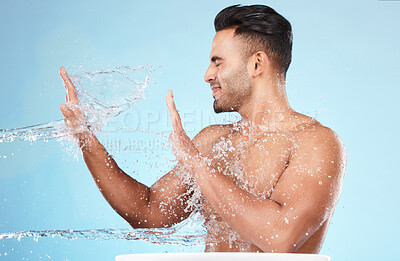 Buy stock photo Body, water splash and skincare of man cleaning in studio isolated on a blue background. Hygiene, water drops and male model washing, bathing or grooming for healthy skin, facial wellness or beauty.