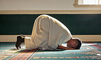 Islam, religion and prayer of a muslim man at mosque in ramadan for spiritual faith, God and belief while doing religious worship. Islamic or Arab culture people sitting to pray at holy place