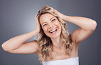 Portrait, beauty and hair with a model woman in studio on a gray background for keratin treatment or natural haircare. Face, skincare and wellness with a female posing to promote a haircare product