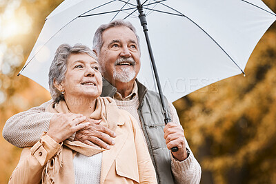 Buy stock photo Love, umbrella and nature with a senior couple outside together, standing in a park during winter or autumn. Forest, retirement and coutryside with a mature man and woman bonding outdoor for dating
