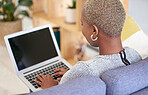 Black woman, blank laptop screen and relax on sofa for marketing mockup, online advertising and digital communication in home. African woman, typing on keyboard and black web homepage for connection