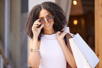 Black woman, shopping and outdoor mall with shopping bag, retail and sale with discount at boutique. Designer brand, fashion and female customer with sunglasses at shopping mall in Los Angeles.