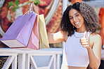 Black woman, shopping and thumbs up with a smile and happiness about sale, discount or promotion with paper bags outdoor. Portrait of female with hand for thank you, advertising and deal on product