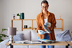 Cleaning, happy and woman with books in the living room, inspection and content with housework. Smile, check and cleaner spring cleaning a book for housekeeping and decluttering in lounge of a house