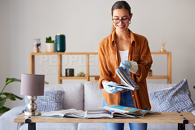 Buy stock photo Cleaning, happy and woman with books in the living room, inspection and content with housework. Smile, check and cleaner spring cleaning a book for housekeeping and decluttering in lounge of a house