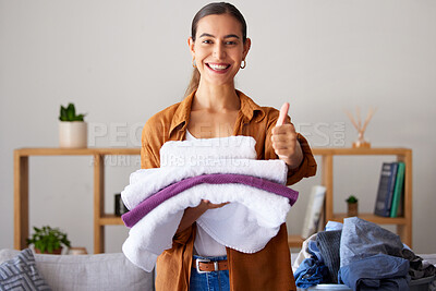 Buy stock photo Thumbs up, laundry and portrait of a woman maid folding clothes in the living room in a modern house. Happy, smile and female cleaner or housewife with a thumbsup cleaning or doing chores in a home.