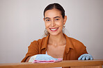 Portrait, cleaning and wipe with a woman housekeeper or cleaner using a rag cloth to dust furniture. Face, bacteria and dirt with a female working to service a dirty apartment for housekeeping