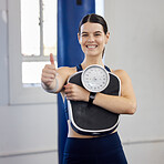 Woman, gym portrait and thumbs up with scale, wellness and weight loss goal for health, body or fitness. Girl, healthy and workout to lose weight, exercise or focus on anatomy, self care or happiness