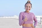 Thumbs up, running and promenade with a sports woman or runner by the beach for cardio or endurance. Winner, motivation and fitness with a female athlete saying yes with a hand gesture outdoor