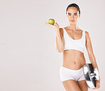 Fitness, health and woman with scale and apple for weightloss, diet and nutrition on white background. Exercise, wellness and girl with fruit, slim body and weight measurement for healthy lifestyle