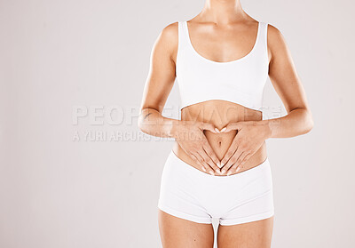 Buy stock photo Health, body and hands in heart of a woman with lose weight results, fitness and beauty goals on studio white background. Underwear, skincare and model woman with gut health, stomach and diet mockup