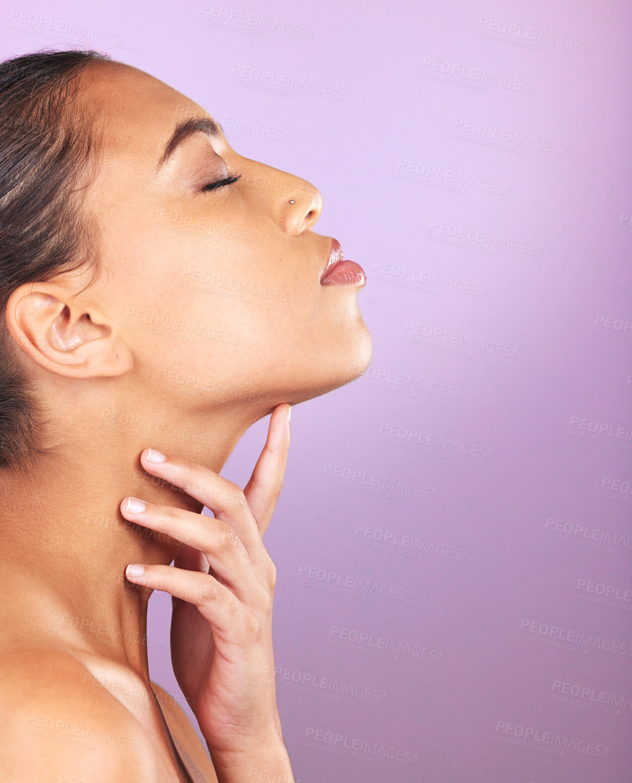 Buy stock photo Beauty, skincare and mockup with a model black woman touching her face in studio on a purple background. Wellness, luxury and cosmetics with an attractive young female posing to promote a product