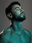Man, face and neon with beauty and skincare, grooming and wellness with eyes closed against studio background. Healthy skin, relax in blue light and peace, self care and cosmetic facial and treatment
