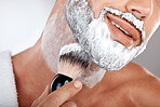 Closeup, man and brush for shaving cream in studio for self care, grooming and facial hygiene with smile. Model, beard and foam for shaving, self love and cleaning for beauty, zoom and skincare