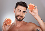Face portrait, skincare and man with grapefruit in studio isolated on a gray background. Wellness, nutrition and male model with fruit for healthy diet, facial care and vitamin c, minerals and beauty