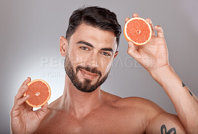 Buy stock photo Face portrait, skincare and man with grapefruit in studio isolated on a gray background. Wellness, nutrition and male model with fruit for healthy diet, facial care and vitamin c, minerals and beauty