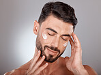 Man, face and beauty with cream for skincare, moisturizer and skin lotion with cosmetics mockup against studio background. Grooming with hands for cosmetic care, facial treatment with wellness.