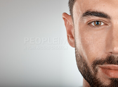 Buy stock photo Face, beauty and eye of a man with clean, glow and healthy skin on a grey studio background for dermatology skincare. Portrait of a male with facial cosmetics for self care with marketing free space