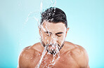 Man, water splash and face cleaning in blue background studio for grooming hygiene, skincare wellness and cosmetics dermatology care. Model, facial spa and body washing or morning beauty routine