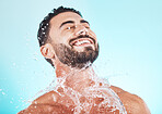 Water, splash and skincare with face of man for shower, self care and natural cosmetics. Luxury, hydration and refreshing with model for dermatology, wellness and cleaning in blue background studio
