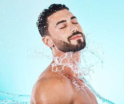 Buy stock photo Water, splash and skincare with face of man for shower, self care and natural cosmetics. Luxury, hydration and refreshing with model for dermatology, wellness and cleaning in blue background studio