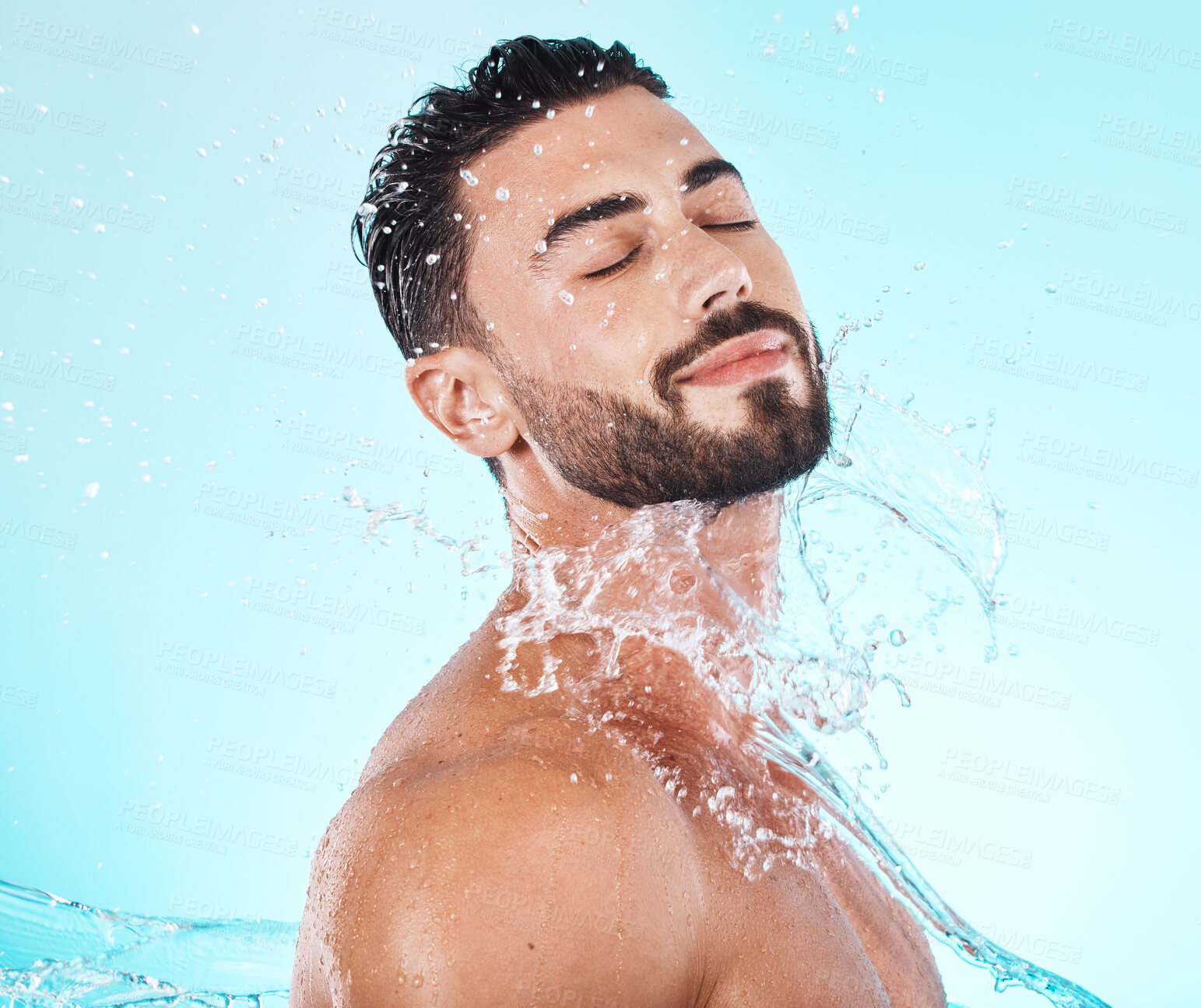 Buy stock photo Water, splash and skincare with face of man for shower, self care and natural cosmetics. Luxury, hydration and refreshing with model for dermatology, wellness and cleaning in blue background studio