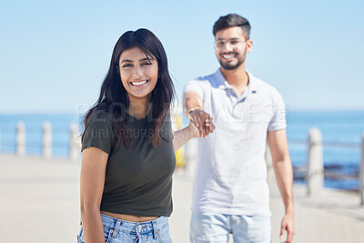 Buy stock photo Beach, love and portrait of a happy couple holding hands while on a seaside summer vacation. Happiness, smile and young man and woman from India walking on the promenade by the ocean while on holiday