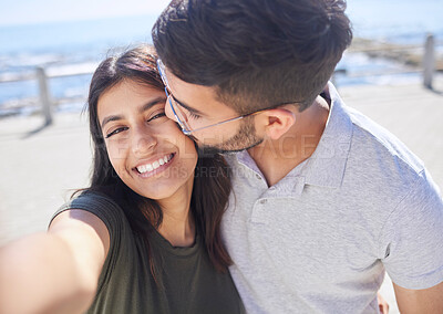 Buy stock photo Couple, love and selfie at the beach, travel and kiss by ocean with support, trust and care with adventure in Mumbai. Smile in picture, happy and memory with smartphone photography for romance 
