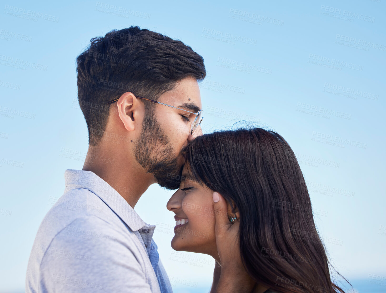 Buy stock photo Couple, forehead kiss and love outdoor with commitment, trust and happy together with bonding and care. Date, romance and relationship with young man, woman profile and smile against sky background