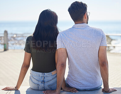 Buy stock photo Beach, view and love with a couple on the promenade together outdoor during summer by the sea or ocean. Back, date and vacation with a man and woman bonding while on holiday by the coast or water