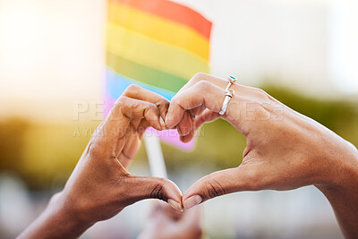 Buy stock photo LGBTQ, pride flag and hands with a heart sign for love, equality and solidarity of a gay couple. Rainbow, freedom and closeup of lesbian women with a hand symbol at a gay pride celebration festival.