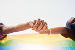 LGBTQ flag, rainbow and couple holding hands for gay pride, lesbian support or human rights protest. LGBT community, sky and African black people together in love, partnership and equality below view